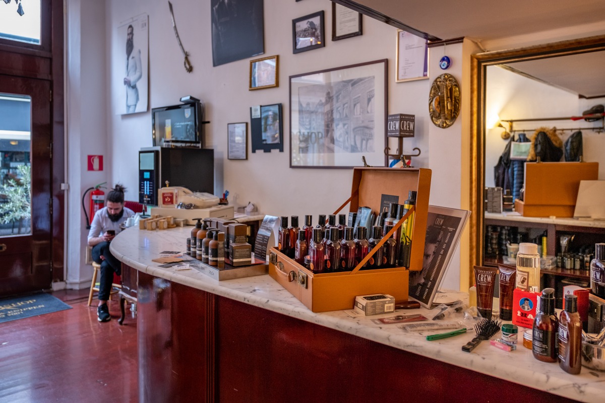 Interieur Sherwany Barbershop — marmeren toonbank, certificaten en verzorgingsproducten